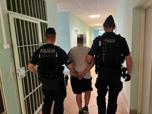 Zdjęcie przedstawiające policjantów prowadzących mężczyznę, który znęcał się nad synem swojej partnerki.