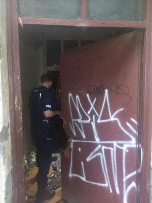 Zdjęcie przedstawiające policjanta podczas kontroli pustostanu.