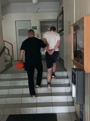 Zdjęcie przedstawiające policjanta prowadzącego zatrzymanego 19-latka.