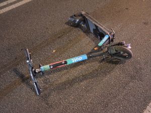 Zdjęcie przedstawiające hulajnogę, leżącą na ulicy.