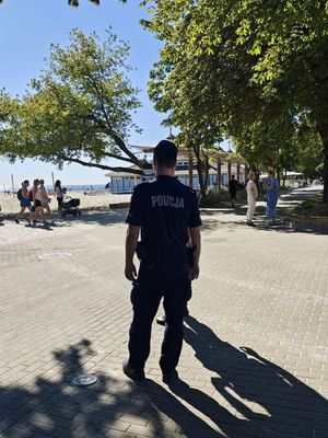 Zdjęcie przedstawiające policjanta podczas patrolowania rejonu plaży miejskiej.