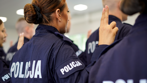 Zdjęcie wykonane z tyłu,  przedstawiające policjantkę podczas uroczystości ślubowania.