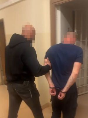 Policjant kryminalny prowadzący zatrzymanego