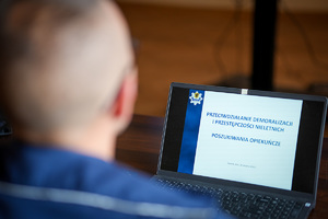 Zdjęcie przedstawiające osobę siedzącą tyłem do obiektywu, mającą przed sobą ekran monitora.