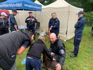 Zdjęcie przedstawiające policjantów, dwie kobiety, mężczyznę, dziecko oraz dwa policyjne psy.