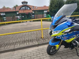 Zdjęcie przedstawiające zaparkowany motocykl przed jedną ze szkół.
