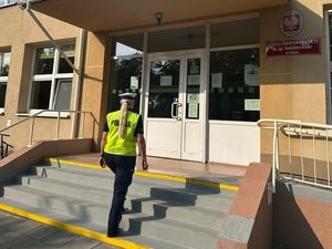 Zdjęcie przedstawiające Policjantkę wchodzącą do szkoły