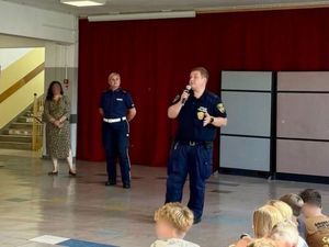 Zdjęcie przedstawiające policjantkę oraz strażnika miejskiego podczas prelekcji w szkole.