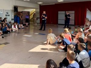 Zdjęcie przedstawiające policjantkę oraz strażnika miejskiego podczas prelekcji w szkole.