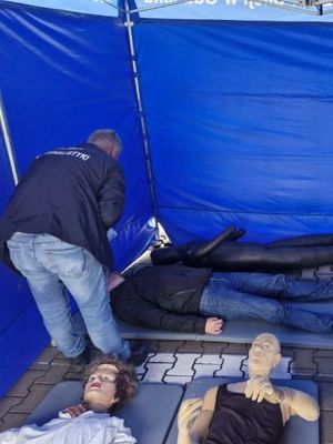 Zdjęcie Przedstawiające mężczyznę przy pozorancie oraz trzy manekiny.