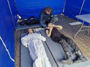 Zdjęcie Przedstawiające mężczyznę przy trzech manekinach.