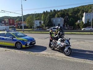 Zdjęcie przedstawia policjanta na motocyklu podczas kontroli drogowej