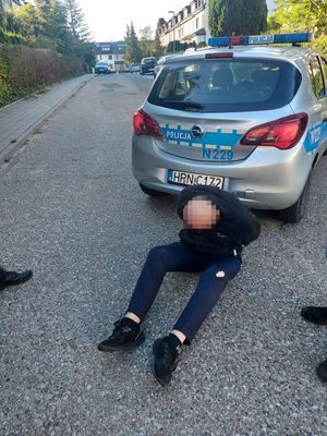 Zdjęcie przedstawiające zatrzymanego mężczyznę siedzącego z tyłu radiowozu.