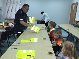 Zdjęcie przedstawiające dzielnicowego wraz z dziećmi, które odwiedziły komisariat