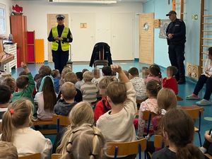 Zdjęcie przedstawiające policjantkę ruchu drogowego oraz dzielnicowego ze Śródmieścia podczas rozmowy z przedszkolakami.
