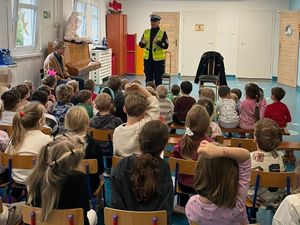 Zdjęcie przedstawiające policjantkę ruchu drogowego  podczas rozmowy z przedszkolakami.