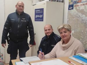 Zdjęcie przedstawia policjantów na spotkaniu rady dzielnicy z mieszkanką