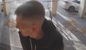 Zdjęcie przedstawia mężczyznę przed bankomatem.