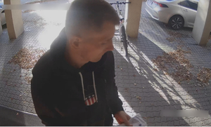 Zdjęcie przedstawia mężczyznę przed bankomatem.