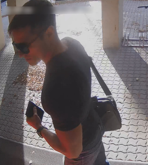 Zdjęcie przedstawia mężczyznę przed bankomatem.