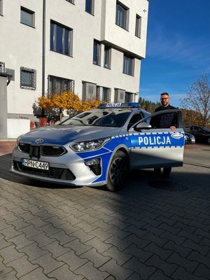 zdjęcie przedstawia policjanta przy radiowozie