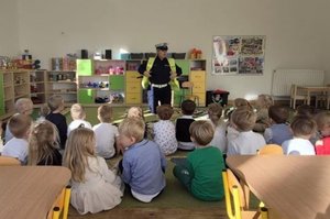 Zdjęcie przedstawia policjantkę, prowadzącą zajęcia z dziećmi.