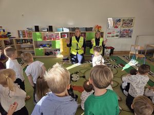 Zdjęcie przedstawia policjantkę, prowadzącą zajęcia z dziećmi.