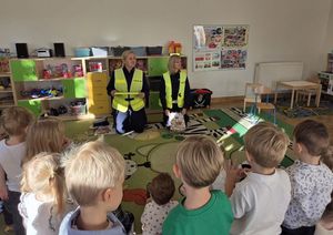 Zdjęcie przedstawia policjantkę, prowadzącą zajęcia z dziećmi.