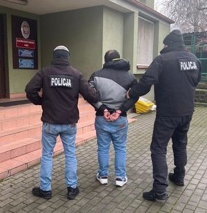 Policjanci prowadzą zatrzymanego.