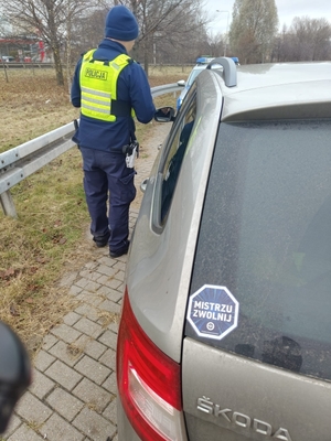 zdjęcie przedstawiaj policjanta podczas kontroli pojazdu
