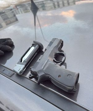 Policjanci z zatrzymanym oraz broń.