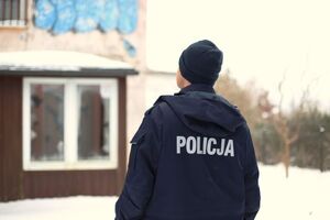 Policjant na tle pustostanu.