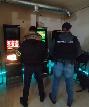 Zdjęcie przedstawia policjanta, mierzącego prędkość i kontrolującego pojazd.