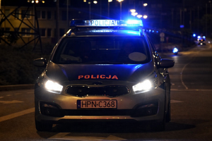 Radiowóz jadący przez miasto na sygnale