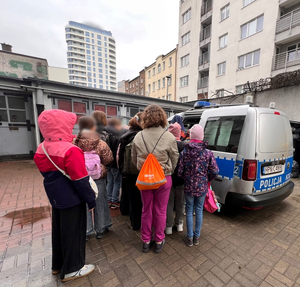 Goście na podwórzu przy radiowozie