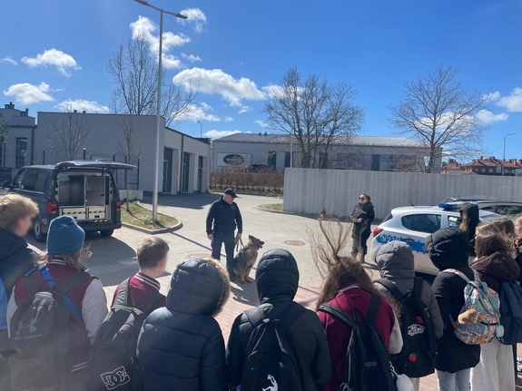 Młodzież podczas wizyty, pies służbowy ze swoim przewodnikiem