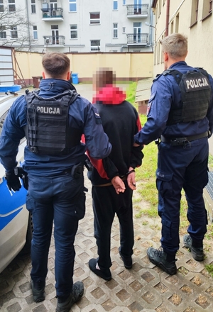 Zatrzymany przy radiowozie i policjantach