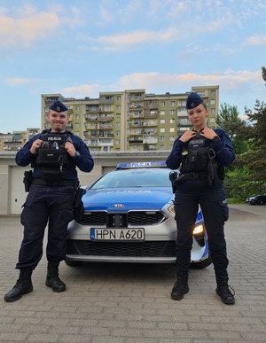 Policjanci przy radiowozie biorący udział w akcji